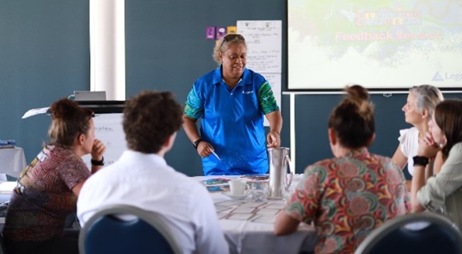 A thumbnail of a woman at a whiteboard talking to a room full of people