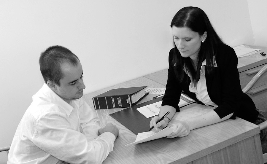 A photo of a lawyer giving advice on a document to a client.