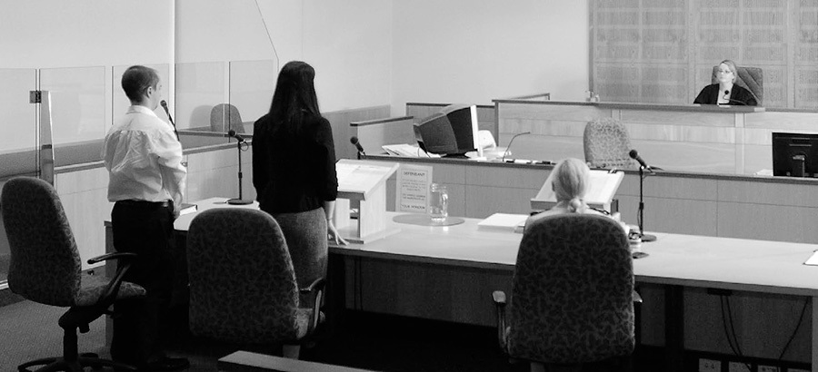 A photo of a defendant in a courtroom giving evidence.