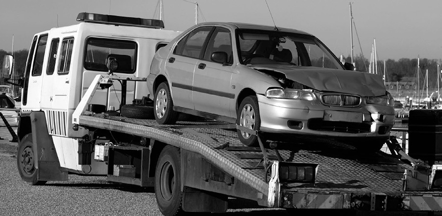 A photo of a smashed car on a tow truck.