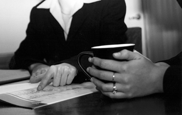 Two people chat over a coffee