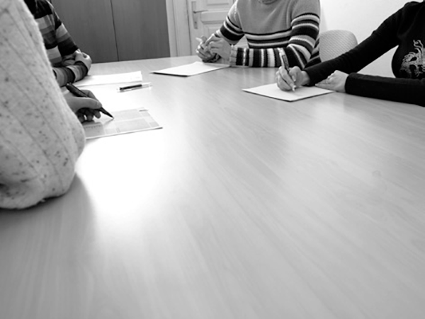 Four people sit around a meeting table